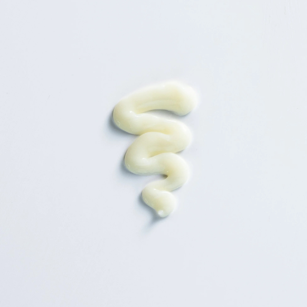 Swirl of creamy off-white Curly Girl Movement Moisture Conditioner Heavy on a white background.