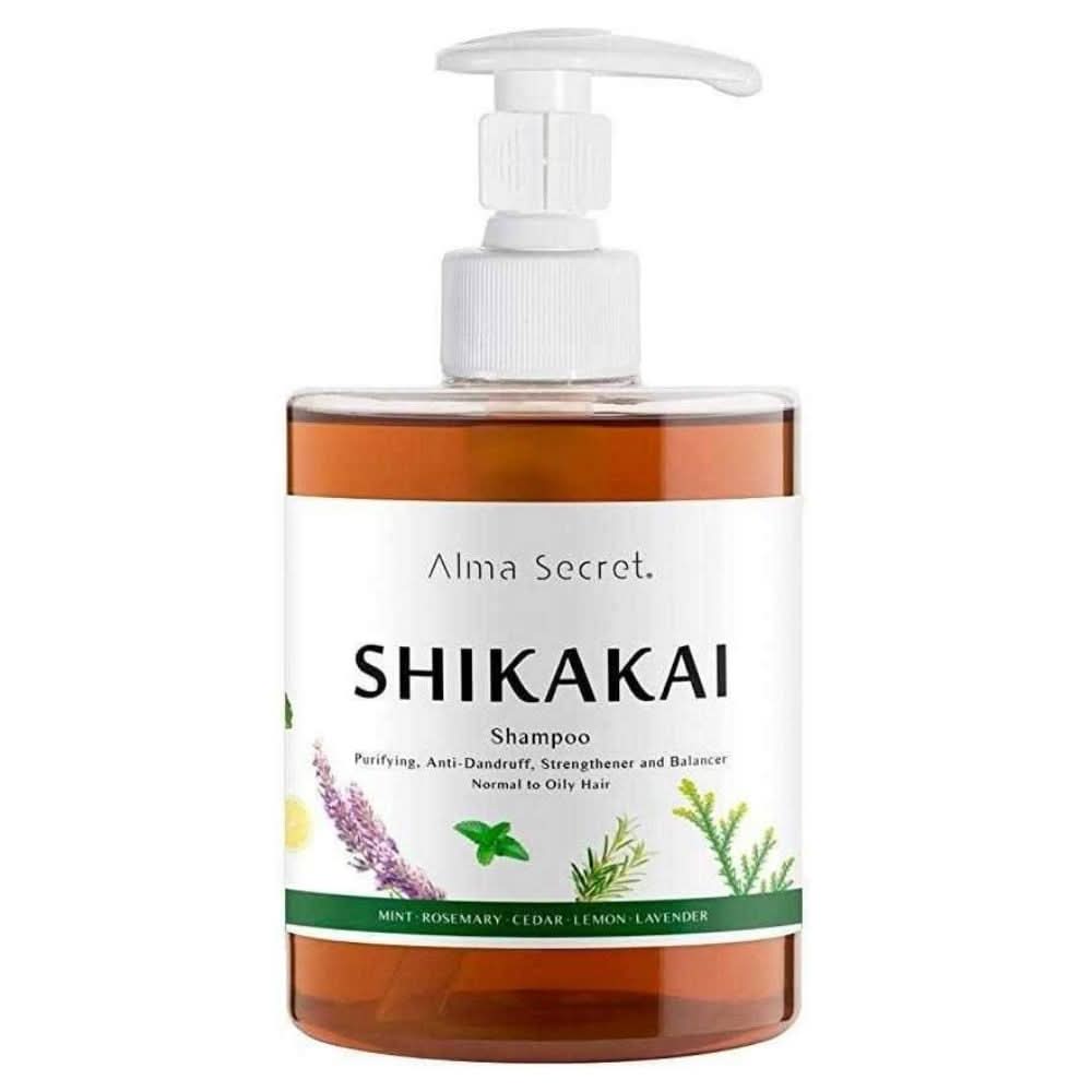 Alma Secret Shikakai Shampoo in a clear 500ml pump bottle with a white label and botanical illustrations.