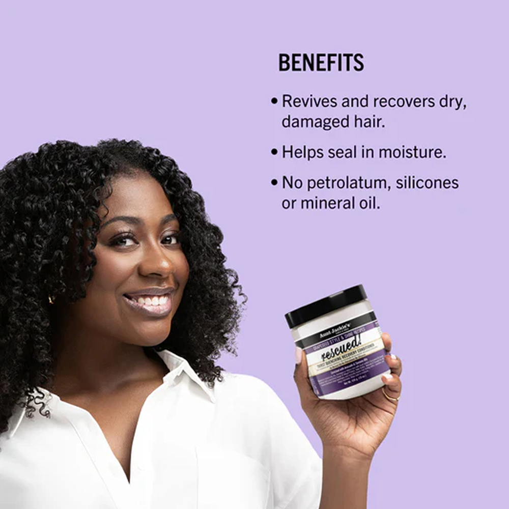 Smiling woman with curly hair holding Aunt Jackie's Rescued! Thirst Quenching Recovery Conditioner jar.