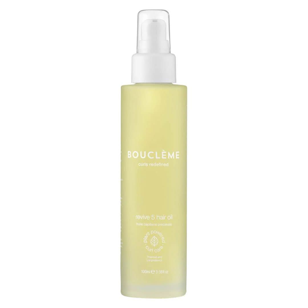 Bouclème Revive 5 Hair Oil 100ml in a clear bottle with a white pump, yellow liquid visible.