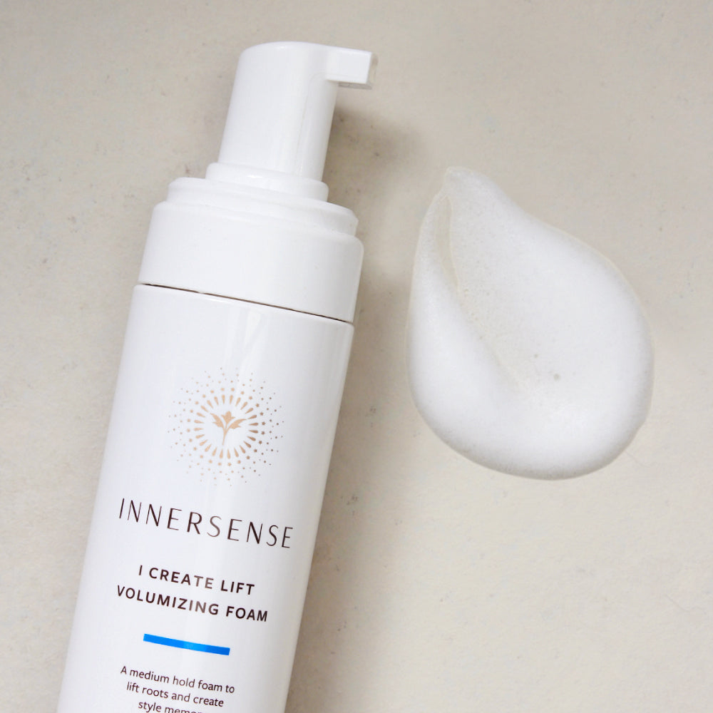 White Innersense I Create Lift Volumizing Foam bottle with a pump and a dollop of white foam beside it.
