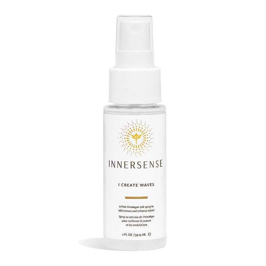 Innersense I Create Waves texturizing spray in a clear bottle with a white pump and gold sun logo.