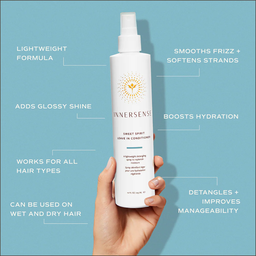 Hand holding white Innersense Sweet Spirit Leave-in Conditioner spray bottle with gold sun logo.