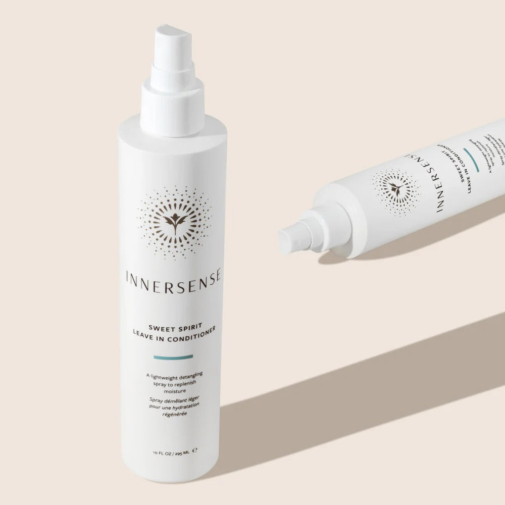 Two white Innersense Sweet Spirit Leave-in Conditioner spray bottles with gold and teal labels on a light background.