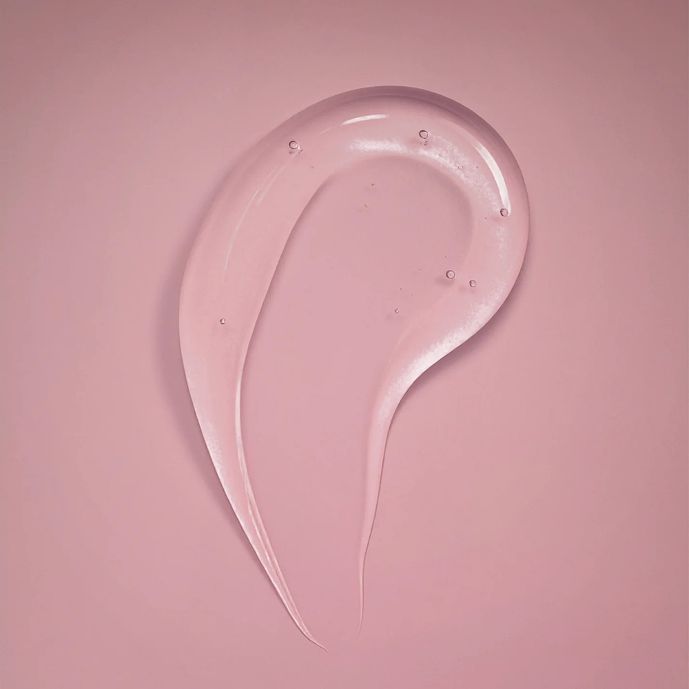 Clear, glossy Ouidad Advanced Climate Control Heat and Humidity Gel swatch on a pink background.